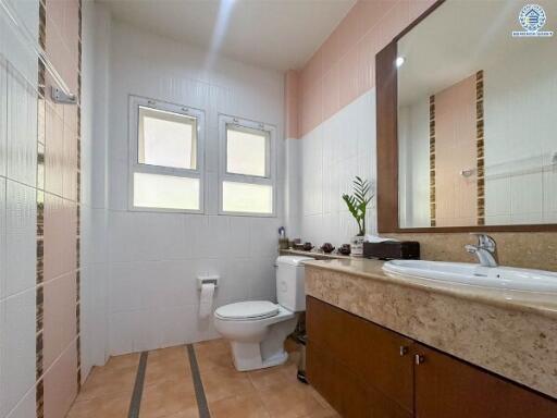 Modern bathroom with a large mirror and window.