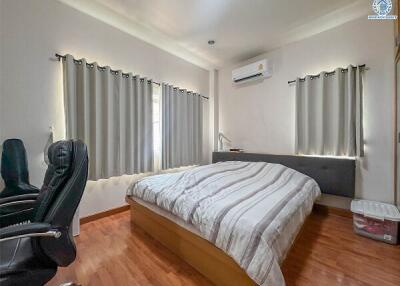 Bedroom with double bed, office chair, and air conditioning