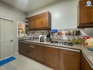 A modern kitchen with wooden cabinets, granite countertops, and stainless steel appliances