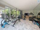 Spacious home fitness room with modern equipment and large windows