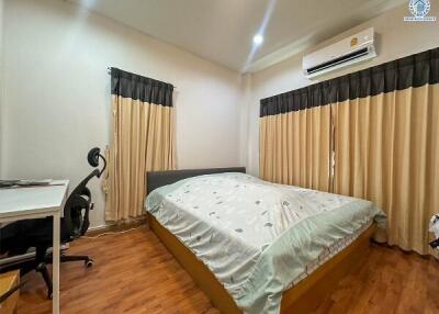 A well-furnished bedroom with a double bed, desk, and office chair.