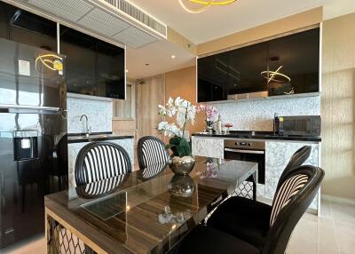 Modern kitchen and dining area with marble countertops and black appliances