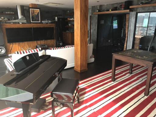 Modern living room with piano, striped rug, and contemporary furniture