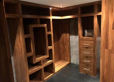 Walk-in closet with wooden shelves and drawers