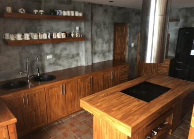 Modern kitchen with wooden cabinets, shelves, and island