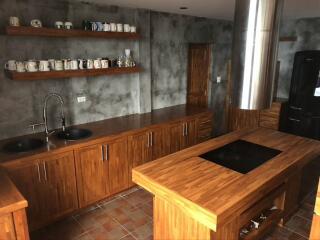 Modern kitchen with wooden cabinets, shelves, and island