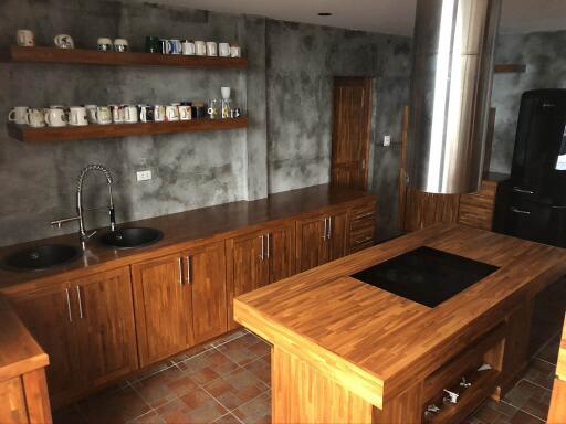 Modern kitchen with wooden cabinets, shelves, and island