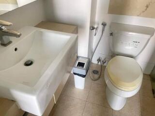 Modern bathroom with sink, toilet, and bidet spray