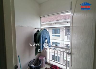 Small balcony with hanging clothes and a view of neighboring building