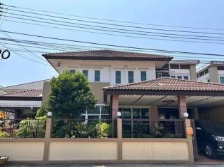 Two-story residential house with a front yard and a fenced boundary