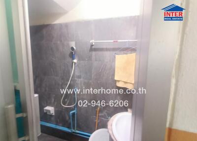 Bathroom with wall-mounted showerhead and washbasin