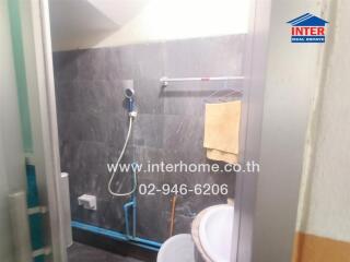 Bathroom with wall-mounted showerhead and washbasin