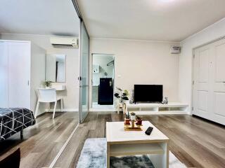 Spacious modern studio apartment with living area, bed, dining space, and kitchenette