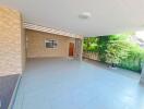 Spacious covered outdoor area with tiled floor and garden view