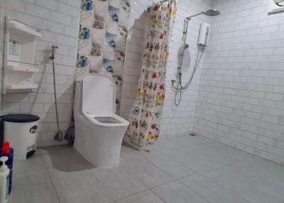 Bathroom with shower, curtain, and toilet