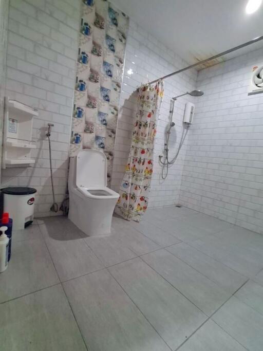 Bathroom with shower, curtain, and toilet