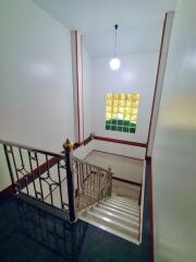 Staircase with decorative railing and pendant light