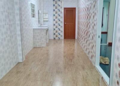 Bright hallway with wooden flooring and tile walls