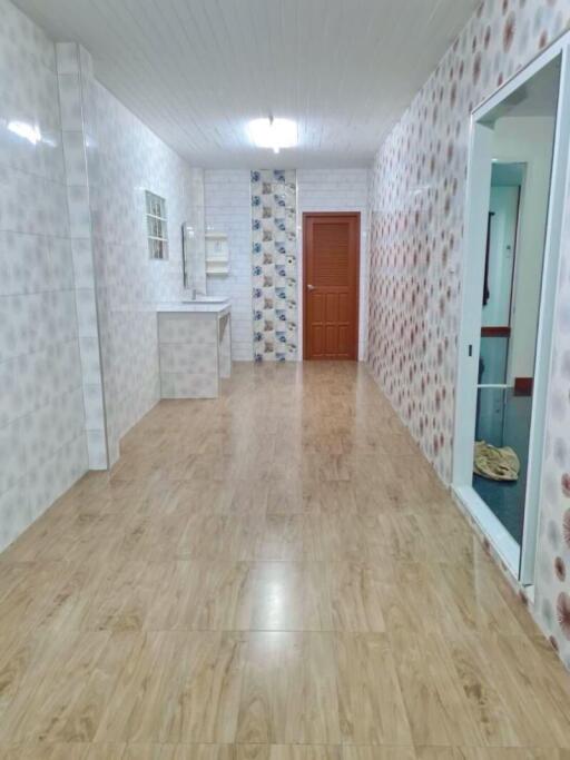 Bright hallway with wooden flooring and tile walls