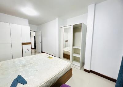 Spacious bedroom with bed, wardrobe, and clean white walls