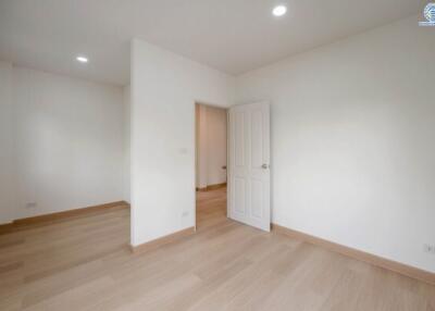 Empty bedroom with hardwood flooring and white walls