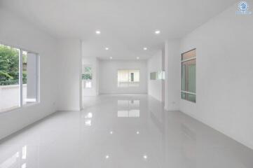 Spacious and empty modern living area with large windows and white tile flooring