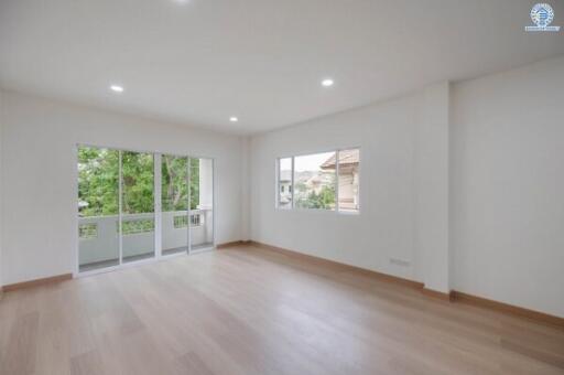 Spacious living room with large windows and hardwood floors