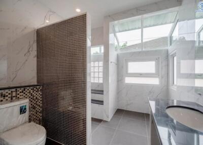Modern bathroom with tiled walls and large windows