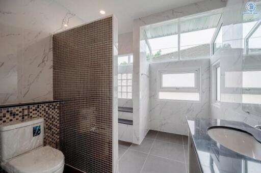 Modern bathroom with tiled walls and large windows