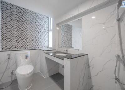 modern bathroom with marble tiles and mosaic accent wall