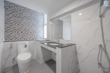 modern bathroom with marble tiles and mosaic accent wall