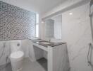 modern bathroom with marble tiles and mosaic accent wall