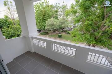 Balcony with a view of a green, tree-filled outdoor space