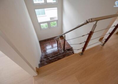 Interior staircase with metal railing and wooden steps