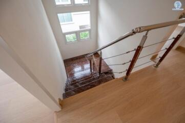 Interior staircase with metal railing and wooden steps