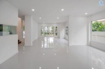 Spacious modern living room with large windows and white interior.