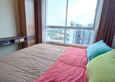 Bedroom with a large window and city view