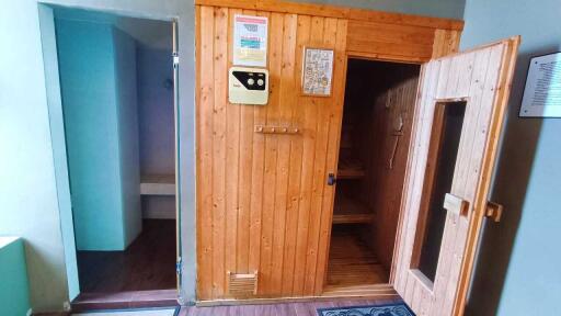 Sauna with open door showcasing interior and adjacent area