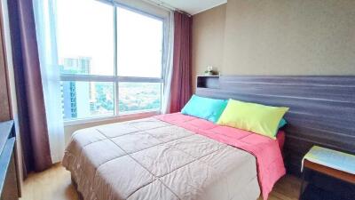 Bright bedroom with large window and colorful bedding