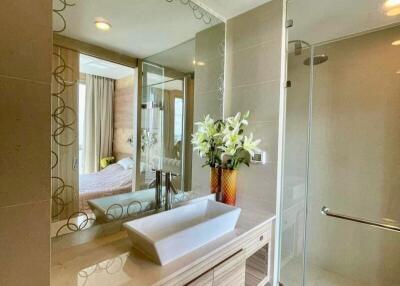 Modern bathroom with a vanity sink, large mirror, and glass shower enclosure