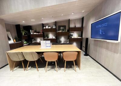 Modern office space with a wooden table, chairs, and shelves