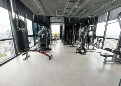 Modern gym with various exercise equipment and city view