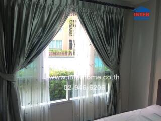 Bedroom with large window and curtains