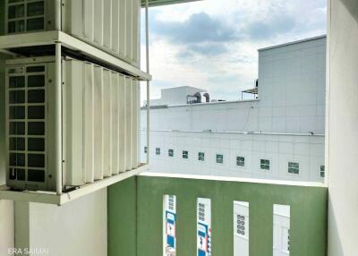 Balcony with view of adjacent buildings and air conditioning units