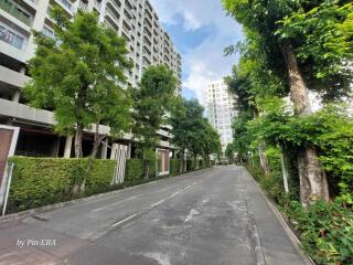 Photograph of a residential building complex with lush green landscaping