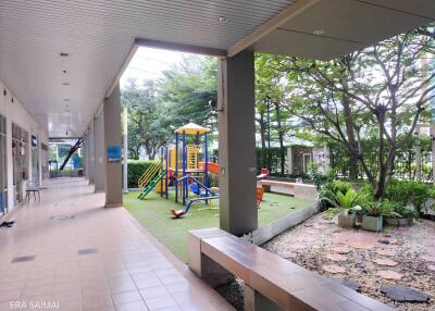 Outdoor playground area with seating and greenery