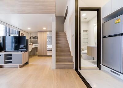 Modern open-plan main living area with stairs, kitchen, and living room