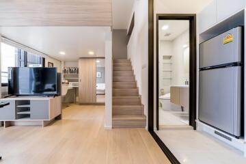 Modern open-plan main living area with stairs, kitchen, and living room