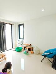 Well-lit living room with modern furniture and pet area