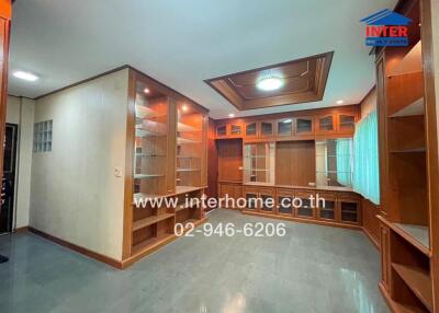 Spacious living room with built-in wooden cabinets and shelves